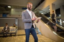 Бізнесмен використовує цифровий планшет в аеропорту — стокове фото