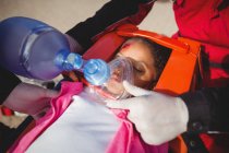 Paramédico dando oxígeno a la chica lesionada en el lugar del accidente - foto de stock