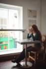 Jovem mulher tomando café no restaurante — Fotografia de Stock