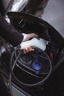 Рука женщины, заряжающей электромобиль на электрозарядной станции — стоковое фото