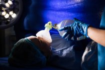 Mano de un médico dando oxígeno a una mujer embarazada en quirófano - foto de stock