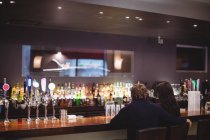 Blick von hinten: Paar trinkt gemeinsam in Bar — Stockfoto