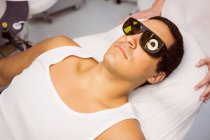 Пацієнт з захисними окулярами, що лежать на лікування в клініці — стокове фото