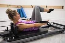 Mulher se exercitando no reformador no estúdio de fitness — Fotografia de Stock