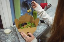 Nahaufnahme einer Frau, die Salat am Cafétisch isst — Stockfoto