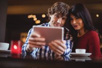 Пара, делающая селфи с помощью цифрового планшета в ресторане — стоковое фото