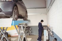 Mécanicien utilisant le boîtier de commande dans le garage de réparation — Photo de stock