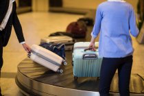 Комп'ютери, які беруть свій багаж з зони позову про багаж в аеропорту — стокове фото