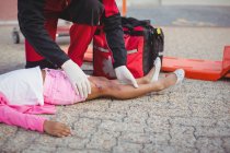 Les ambulanciers examinent une fille blessée dans la rue — Photo de stock