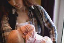 Nahaufnahme einer Mutter, die ihr Neugeborenes zu Hause stillt — Stockfoto