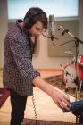 Man adjusting volume while singing in music studio — Stock Photo