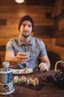 Retrato de homem mostrando copo no restaurante — Fotografia de Stock