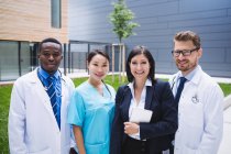 Портрет улыбающихся врачей, стоящих вместе в помещении больницы — стоковое фото