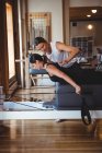 Trainer helping a woman while practicing pilates in fitness studio — Stock Photo