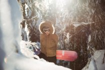 Woman with snowboard walking on snow covered mountain — Stock Photo