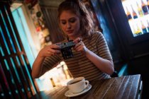Frau klickt auf ein Bild von Kaffee in der Bar — Stockfoto