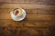 Taza de café y platillo en una mesa en la cafetería - foto de stock