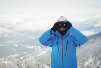 Лижник, дивлячись на гірських через Бінокулярний — стокове фото