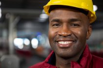 Close up retrato de trabalhador masculino vestindo chapéu amarelo duro na fábrica — Fotografia de Stock