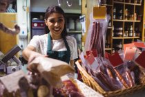 Female staff working at meat counter in supermarket — Stock Photo