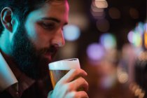 Primo piano dell'uomo che beve un bicchiere di birra al bar — Foto stock