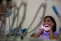 Patiente effrayée lors d'un examen dentaire en clinique dentaire — Photo de stock