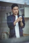 Business executive using mobile phone in office — Stock Photo