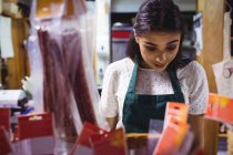 Personal femenino que trabaja en el mostrador de alimentos en el supermercado - foto de stock