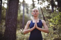 Schöne Frau meditiert an einem sonnigen Tag im Wald — Stockfoto