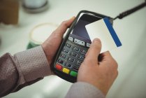 Close-up de mãos fazendo o pagamento através de cartão de crédito no café — Fotografia de Stock