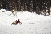 Esquiadores montando snowmobile em alpes nevados durante o inverno — Fotografia de Stock