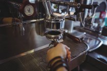 Офіціантка тримає портативний фільтр, наповнений меленою кавою в кафе — стокове фото