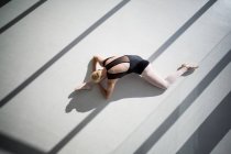 Вид зверху на балерину, що тягнеться на підлогу — стокове фото