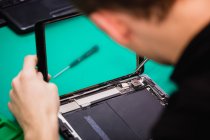 Mann repariert digitales Tablet in Reparaturzentrum — Stockfoto