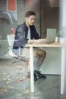 Бізнес-виконавчий, що працює на ноутбуці в офісі — стокове фото