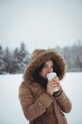 Mulher bonita na jaqueta de pele que toma café durante o inverno — Fotografia de Stock