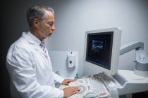 Cirujano operando máquina de dispositivo ultrasónico en el hospital - foto de stock