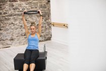 Femme faisant de l'exercice sur le réformateur dans un studio de fitness — Photo de stock