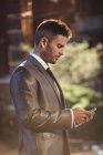 Businessman using mobile phone near office building — Stock Photo