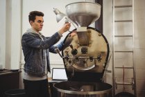 Homem usando máquina de moagem de café no café — Fotografia de Stock