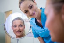Щасливі жінка перевірка шкіри в дзеркало після отримання косметичне лікування — Stock Photo