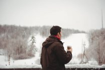 Uomo che beve caffè sul balcone godendo della vista — Foto stock