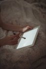 Крупним планом жінка використовує цифровий планшет у ліжку — стокове фото
