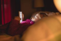 Mädchen ruht sich aus und benutzt digitales Tablet im Schlafzimmer zu Hause — Stockfoto
