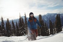 Mann läuft auf schneebedecktem Berg gegen Bäume — Stockfoto