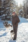 Homem de pé com grupo de cães husky siberianos — Fotografia de Stock