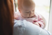 Nahaufnahme einer Mutter, die ihr süßes Baby zu Hause trägt — Stockfoto