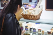 Женщина смотрит на пищевой дисплей в супермаркете — стоковое фото