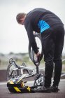 Ciclista reparando una bicicleta BMX en skatepark - foto de stock