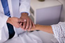Medico di sesso maschile confortante paziente anziana in reparto in ospedale — Foto stock